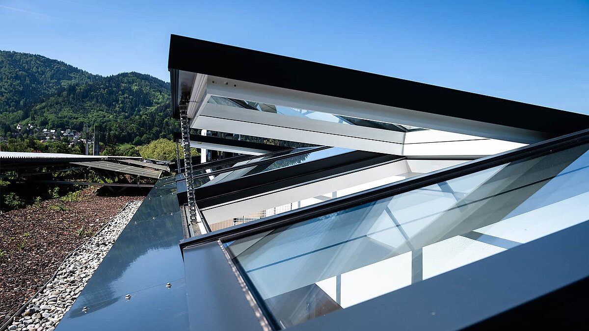 Wohnhaus in Freiburg mit modularen Glasdächern von LAMILUX, Blick auf die geöffnete Dachkonstruktion.