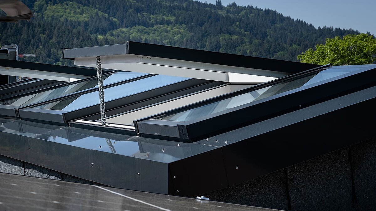 Nahaufnahme eines modularen Glasdachs von LAMILUX in einem Wohnhaus in Freiburg, teilweise geöffnet zur Belüftung.