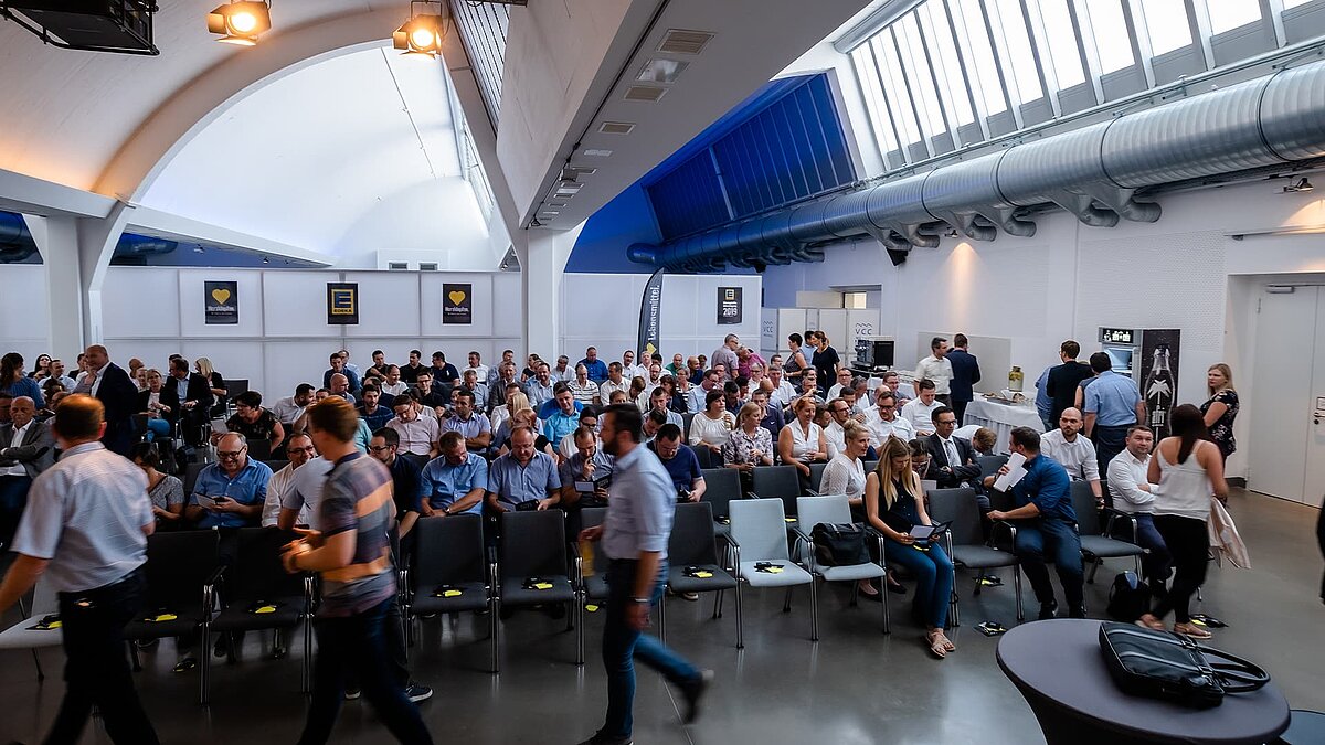 Innenansicht des Vogel-Convention-Centers in Würzburg mit einer Versammlung von Teilnehmern unter modernen Glasdächern.