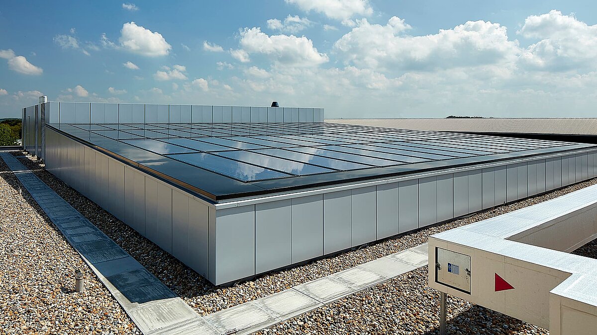 Glasdach einer modernen Gewerbeimmobilie im Milton Park, England, reflektiert den Himmel und sorgt für natürliche Beleuchtung.