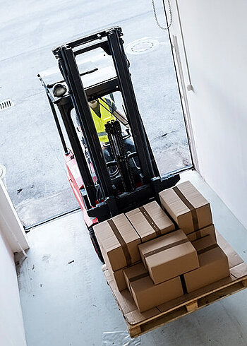 Gabelstapler transportiert Kartons auf einer Palette.