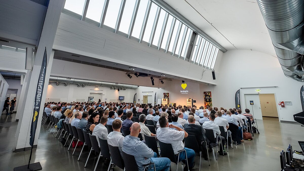 Veranstaltung im Vogel-Convention-Center in Würzburg, mit Teilnehmern in einem Saal unter einem Glasdach