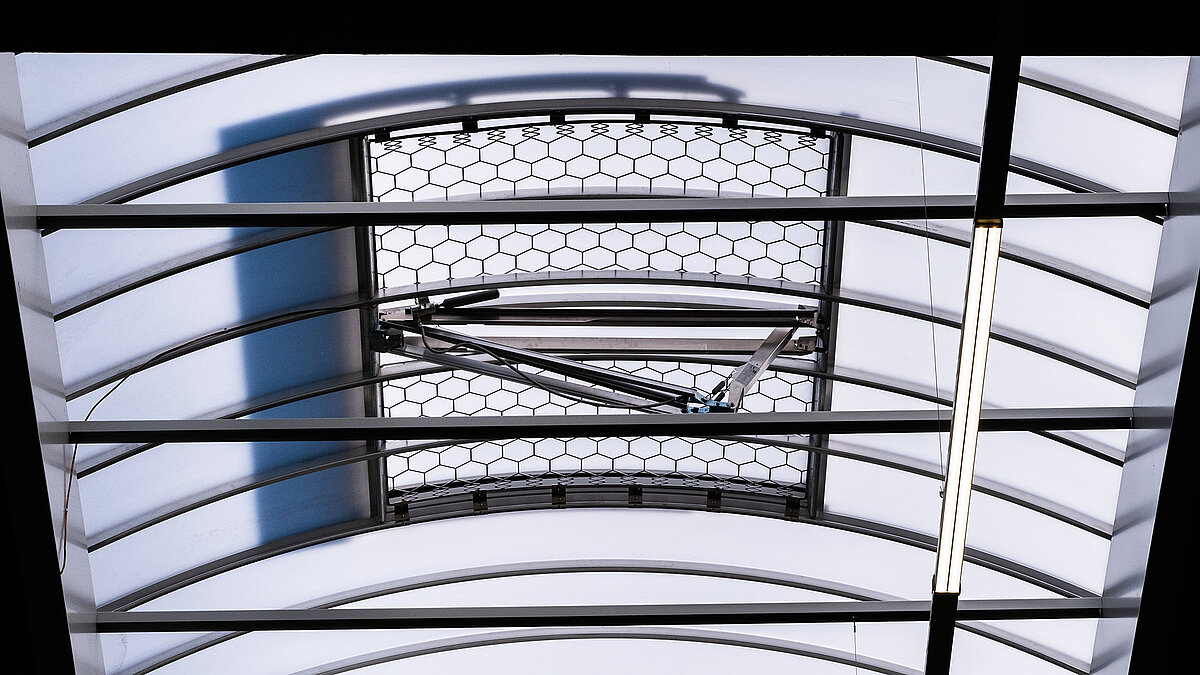 Detailaufnahme einer LAMILUX Lichtkuppel F100 W mit integriertem Lüftungsmechanismus in der Produktionshalle des Bauunternehmens Unglehrt.